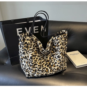 Close-up of leopard print quilted tote bag with diamond stitching and black shoulder straps
