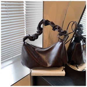 Détail du sac à bandoulière plissé en cuir brillant marron foncé avec poignée froncée et cordon