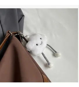 Dettaglio del ciondolo nuvola di peluche bianco con gambe a righe su una borsa