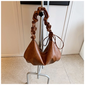Détail du sac à main marron caramel en simili cuir avec bandoulière plissée et cordon chic