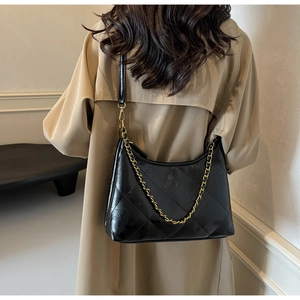 Détail du sac hobo en cuir matelassé noir avec chaîne dorée et finition brillante