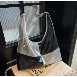 Close-up of contrast silver and black hobo bag with metallic sphere ornaments