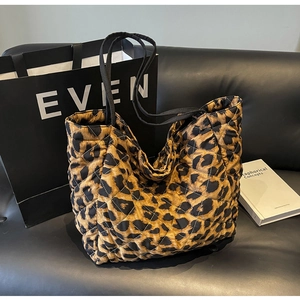Detail of leopard print quilted tote bag with diamond stitching and black straps