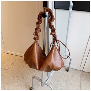 Détail de la poignée plissée marron vintage et de la fermeture éclair métallique du sac