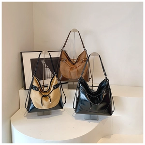 Detail view of large hobo bags showing suede and leather patchwork with drawstring