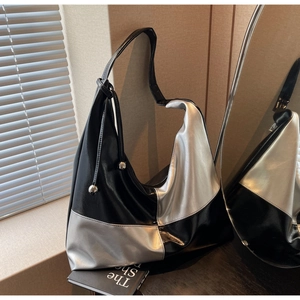 Detail of a large silver and black hobo bag with metallic bead buckle on shoulder strap