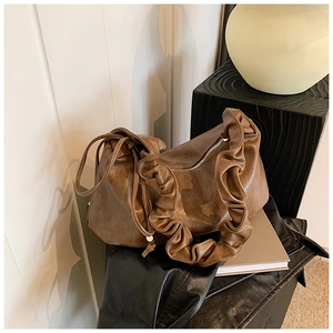 Détail d'un sac hobo vintage en cuir marron avec bandoulière à volants et cordon