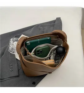 Internal view of brown pebble leather bucket bag showing large multi-layer storage capacity