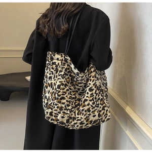 Quilted leopard print tote bag with leather straps shown from a back-view perspective