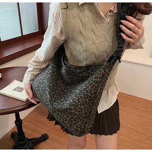 Detail der hobo-tasche mit leopardenmuster, gerüschtem schultergurt und großem fassungsvermögen