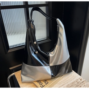 Detail of hobo bag featuring black and silver color-blocking with metallic beads