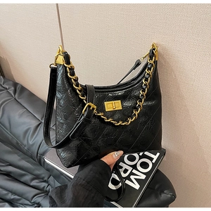 Dettaglio della borsa hobo in pelle trapuntata nera con finitura lucida e catena dorata