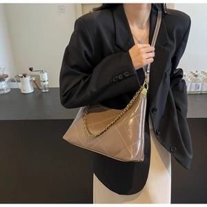 Gros plan du sac marron matelassé avec chaîne et coutures blanches élégantes contrastées