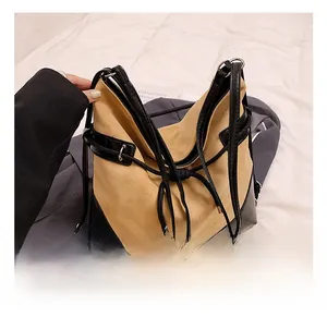 Close-up of contrast stitching, khaki suede texture and black leather drawstring details