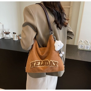 Vue détaillée du sac cabas en daim marron avec broderie HOLIDAY et breloque nuage
