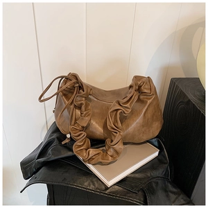 Détail d'un sac hobo marron en similicuir avec bandoulière plissée et fermeture éclair