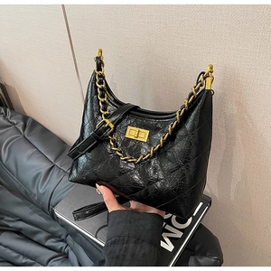 Dettaglio borsa trapuntata nera con catena dorata e chiusura metallica a rotazione