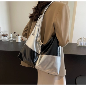 Detail of silver and black contrast tote bag with metallic texture and silver sphere charm