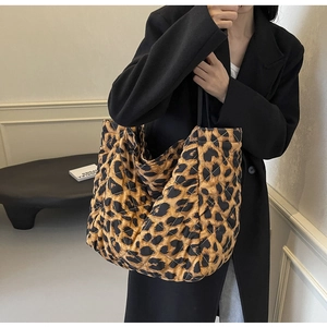 Quilted tote bag detail featuring creative heart and leopard print with black shoulder straps