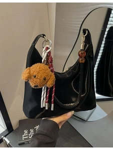 Bolso de hombro en charol negro brillante con un lindo colgante de oso de peluche