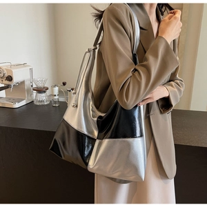 Detail view of a large two-tone black and silver tote bag with metallic adjustment buckle