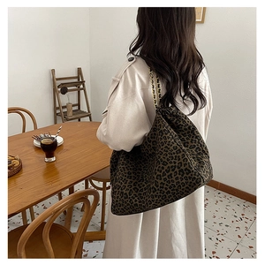 Fashionable leopard print tote bag with golden chain strap shown in a lifestyle setting