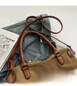 Détail du sac cabas en toile marron avec poignées en cuir sur veste en jean