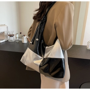 Close-up of stylish black and silver checkered hobo bag with metallic ball strap detail