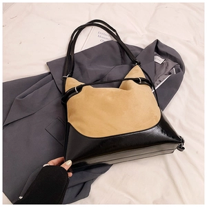 Detail of large suede and leather contrast shoulder bag with dual black straps