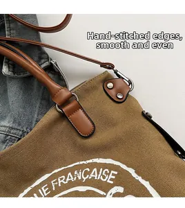 Détail du sac cabas en toile avec poignée en cuir et logo lettre vintage