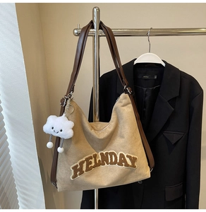 Détail du sac cabas kaki avec broderie HELNDAY et breloque nuage en peluche blanche suspendu
