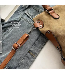 Détail du crochet rotatif en métal et de la poignée en cuir d'un sac en toile