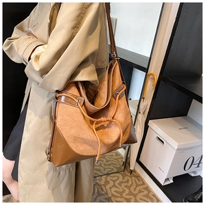 Detail of caramel suede and dark brown leather tote bag with drawstring knots on shoulder