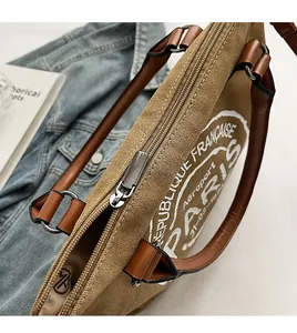 Détail du sac fourre-tout en toile kaki avec fermeture éclair et anses en cuir