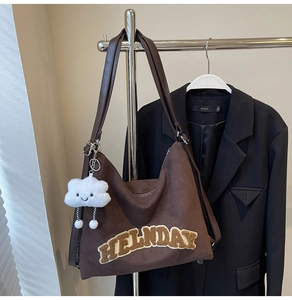 Détail du sac cabas en daim marron avec broderie HELLNDAY et pendentif nuage