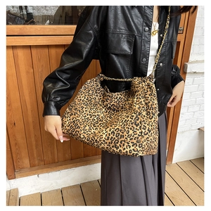 Detail view of large leopard print tote bag with gold chain strap and pleated opening