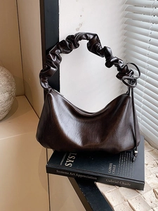 Grand sac à bandoulière marron foncé vintage avec poignée froncée sur des livres