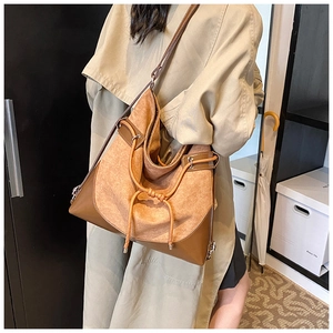 Detail view of large brown suede tote bag with drawstring knot and wide strap