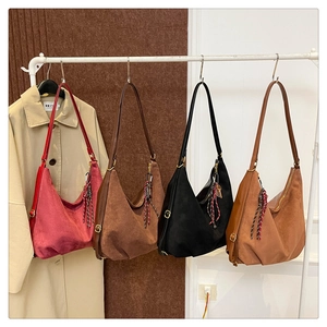 Detail of multi-color frosted hobo bags with woven tassels and metal buckles