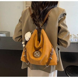 Détail du sac fourre-tout jaune moutarde avec charm ours en peluche et logo M en métal