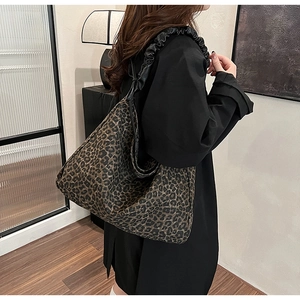 Detailansicht einer großen Schultertasche mit Leopardenmuster und schwarzen Trägern