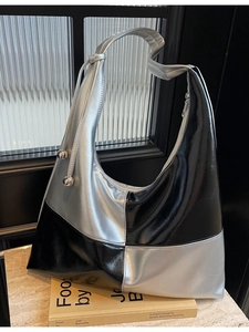 Chic black and silver color-block crescent shoulder bag with metallic drawstring detail