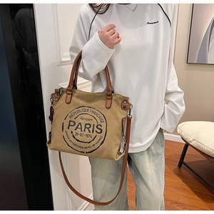 Vue détaillée du sac cabas en toile kaki avec imprimés vintage de Paris et anses en cuir marron
