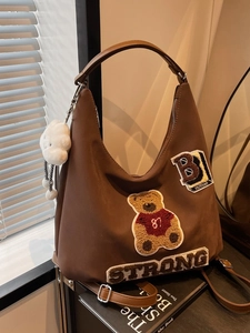 Brown canvas tote bag with bear embroidery, strong lettering and cloud charm
