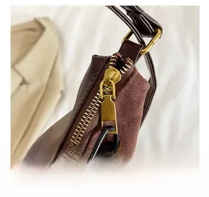 Detail view of burgundy PU leather tote featuring gold zipper and metal abacus charm
