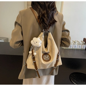 Détail du grand sac cabas beige avec logo M métallique et pendentif nuage en peluche