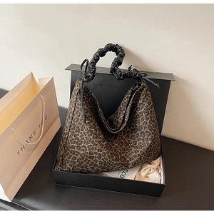 Detail der hobo-tasche mit leopardenmuster und gerafftem griff in eleganter geschenkbox