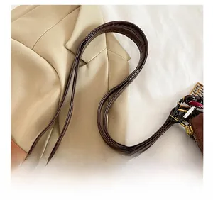Detail of adjustable leather strap and vintage gold buckle on brown suede tote bag