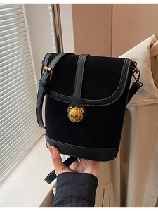 Chic black faux suede bucket bag with gold bear buckle and adjustable strap