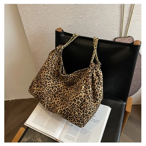 Detail of leopard print tote bag featuring gold chain straps and pleated design
